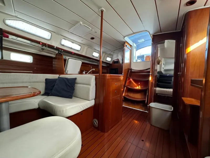 Slide: The Image of Interior of 2004 Beneteau Oceanis Clipper 473 yacht with wood finish and white seating. - 44
