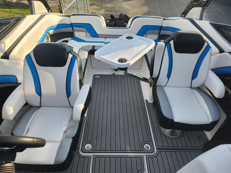 Slide: The Image of 2016 Yamaha Boats 242X E-Series interior with white and blue seating, table, and sleek flooring. - 18