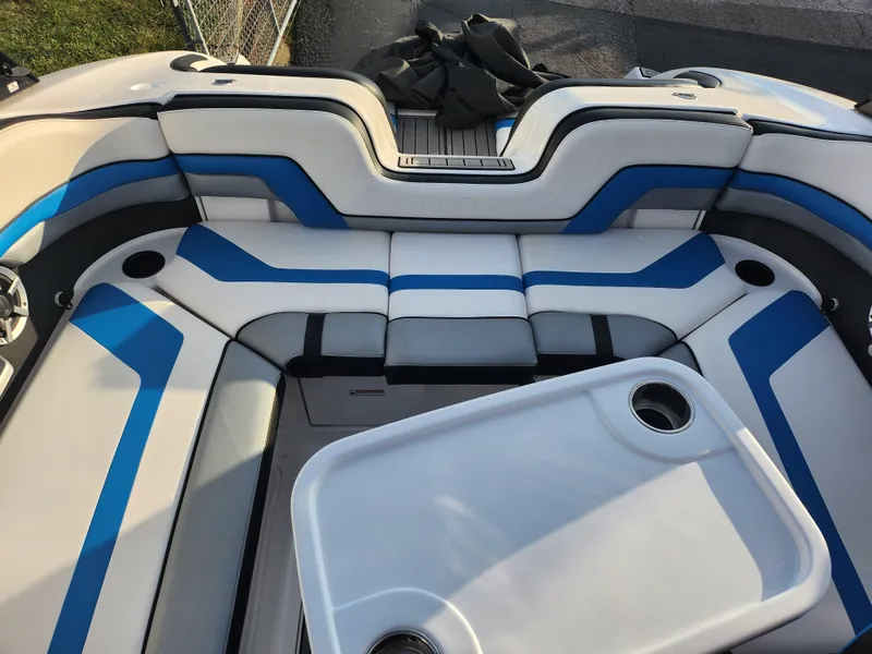 Slide: The Image of 2016 Yamaha Boats 242X E-Series interior with blue and white seating and table. - 19