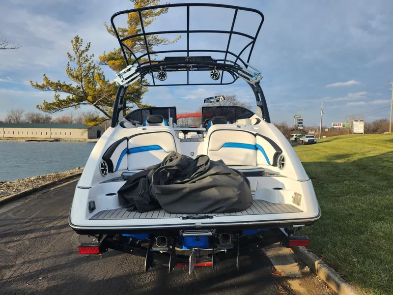 Slide: The Image of 2016 Yamaha Boats 242X E-Series on a lakeside road, showcasing rear view and seating. - 2