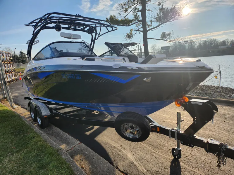 Slide: The Image of 2016 Yamaha Boats 242X E-Series on trailer by a lakeside. - 8