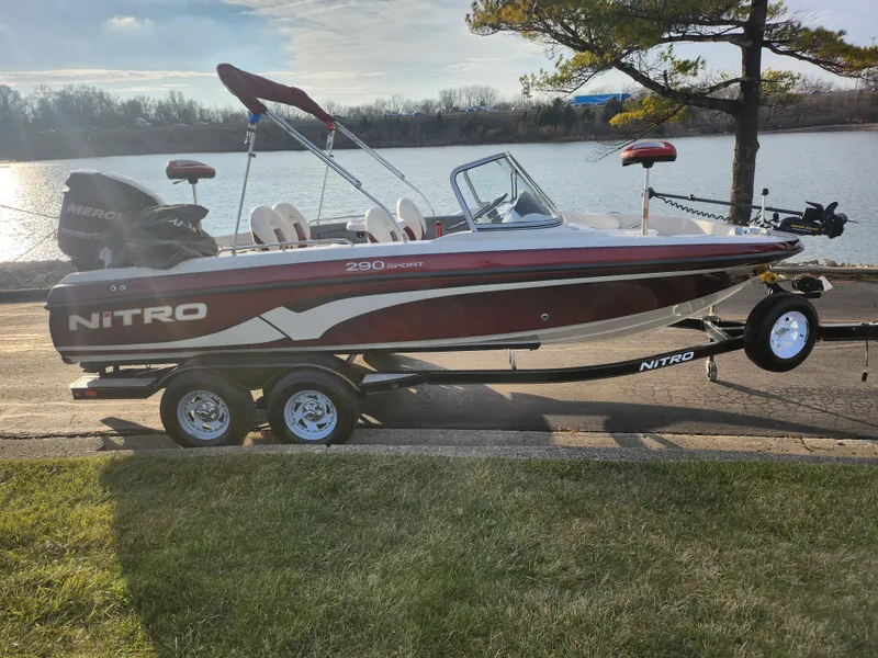 Slide: The Image of 2013 Nitro 290 Sport boat on trailer by a lake. - 10