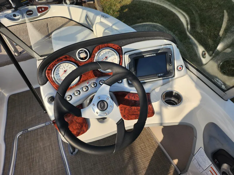 Slide: The Image of 2013 Nitro 290 Sport boat dashboard with steering wheel and navigation system. - 14