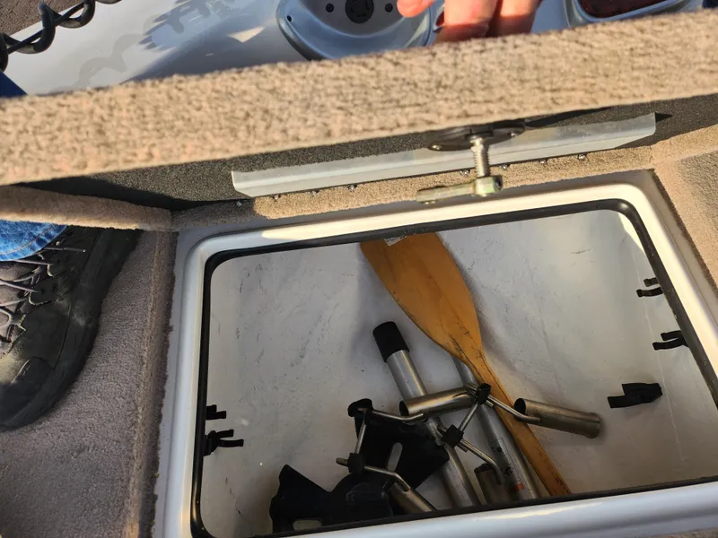 Slide: The Image of Open storage compartment in 2013 Nitro 290 Sport boat with paddles and equipment. - 18