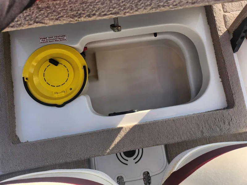 Slide: The Image of 2013 Nitro 290 Sport boat storage compartment with yellow lid. - 22