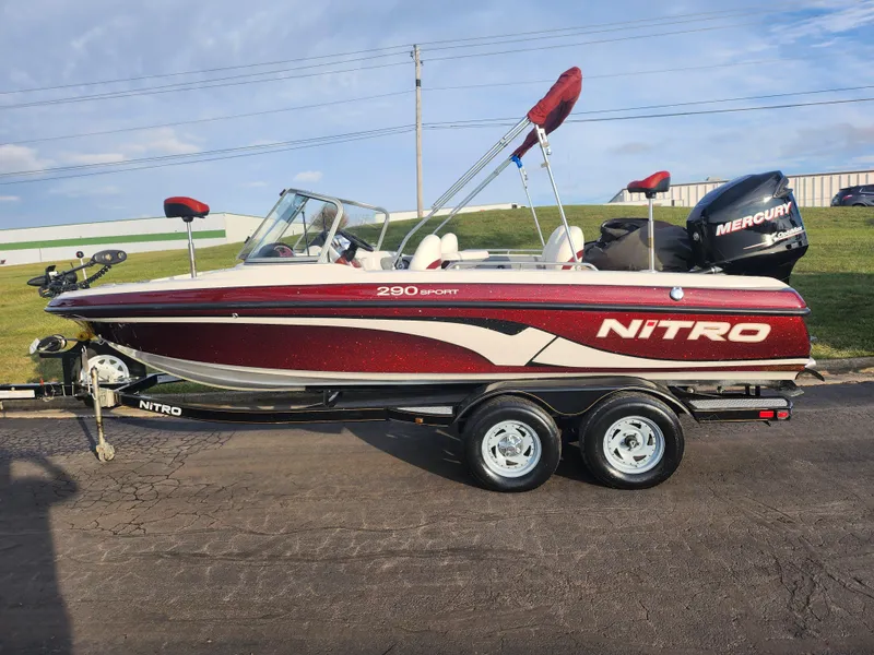 Slide: The Image of 2013 Nitro 290 Sport boat on trailer, red and white design, parked outdoors. - 4