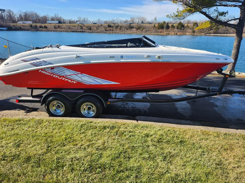Slide: The Image of 2008 Yamaha Boats 212SS in red on trailer by a lake. - 11
