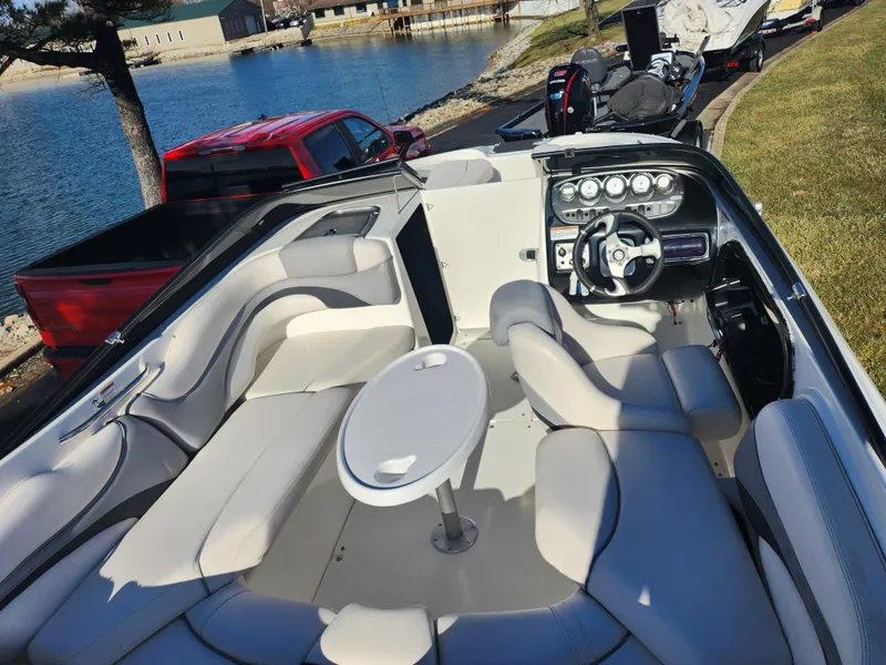 Slide: The Image of 2008 Yamaha Boats 212SS interior with seating and steering wheel, docked by a lake. - 12