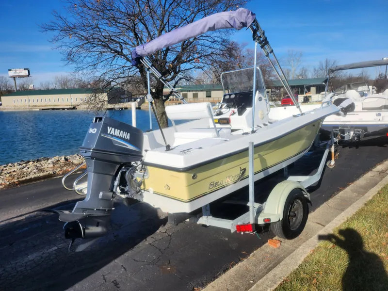 Slide: The Image of 2008 Sea King 180CC boat with Yamaha motor on trailer by a lake. - 2