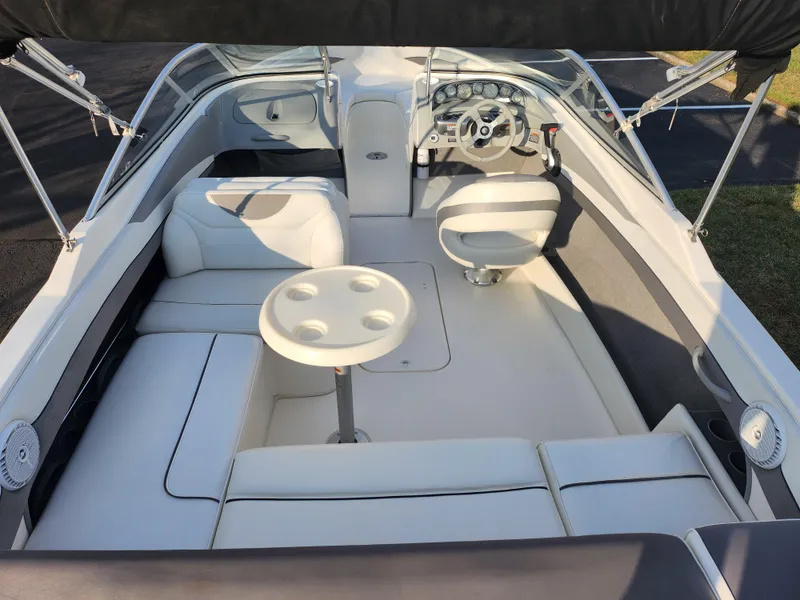 Slide: The Image of 2007 Bayliner 225 boat interior with white seating and steering wheel. - 10