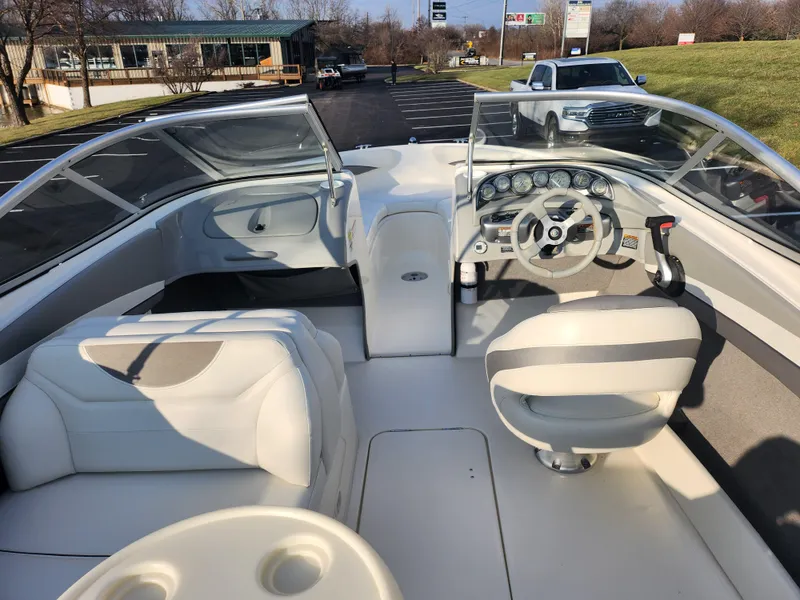 Slide: The Image of 2007 Bayliner 225 boat interior with steering wheel and seating. - 11