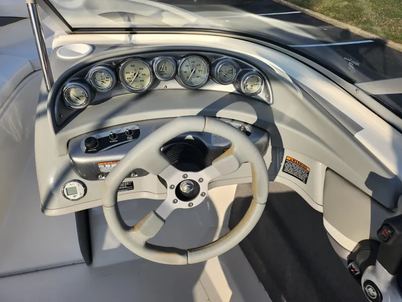 Slide: The Image of 2007 Bayliner 225 boat dashboard with steering wheel and gauges. - 14
