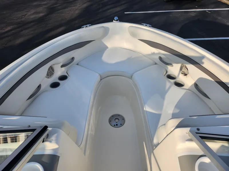 Slide: The Image of 2007 Bayliner 225 boat interior with white seating and cup holders. - 17