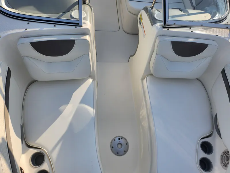 Slide: The Image of 2007 Bayliner 225 boat interior with white seating and cup holders. - 18