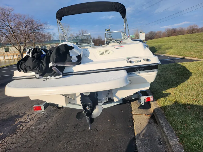 Slide: The Image of 2007 Bayliner 225 boat parked on pavement, rear view with outboard motor. - 2