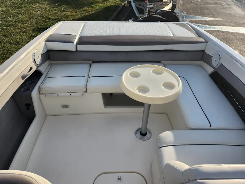 Slide: The Image of 2007 Bayliner 225 boat interior with seating and a round table. - 21