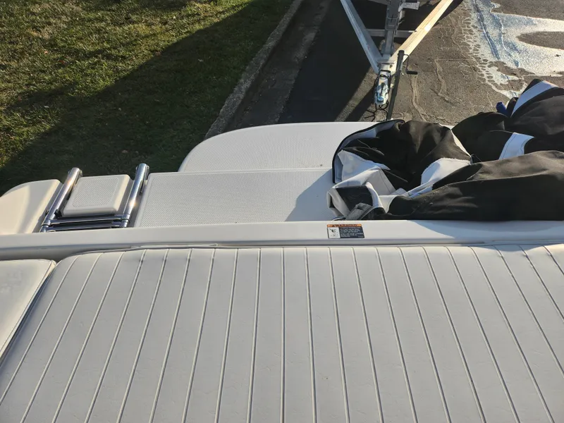 Slide: The Image of Bayliner 225 boat deck, 2007 model, with ladder and cover, parked on trailer. - 24