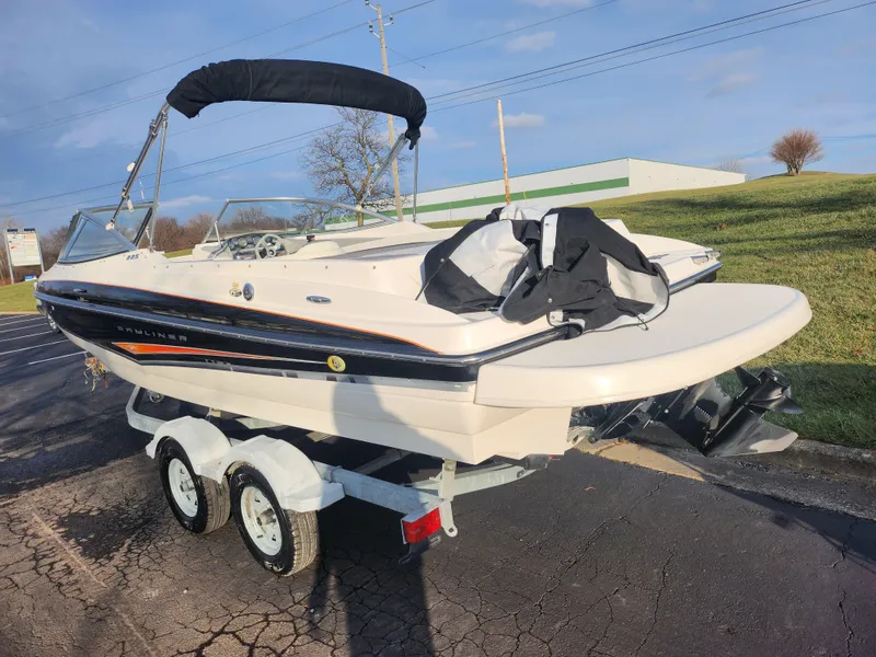 Slide: The Image of 2007 Bayliner 225 boat on trailer, parked outdoors under clear sky. - 3