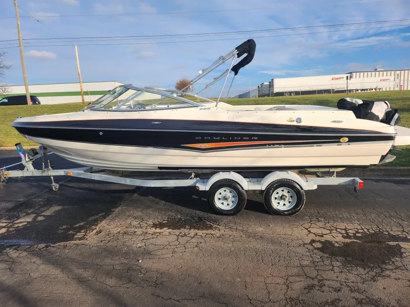 Slide: The Image of 2007 Bayliner 225 boat on trailer, parked outdoors under clear sky. - 4