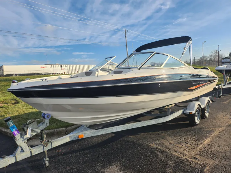 Slide: The Image of 2007 Bayliner 225 boat on trailer, parked outdoors under blue sky. - 5
