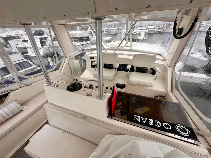 Slide: The Image of 1989 Viking 44 Motor Yacht interior with helm, seating, and marina view. - 10