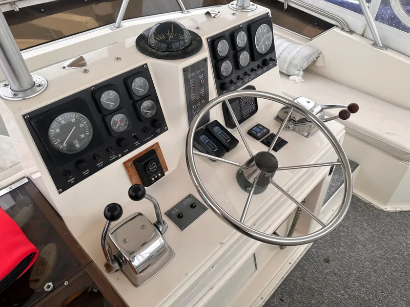 Slide: The Image of 1989 Viking 44 Motor Yacht helm with steering wheel, gauges, and controls. - 11