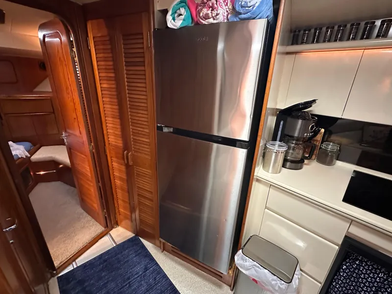 Slide: The Image of 1989 Viking 44 Motor Yacht kitchen with stainless steel fridge, coffee maker, and wooden cabinetry. - 22