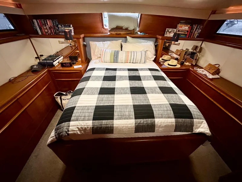 Slide: The Image of 1989 Viking 44 Motor Yacht bedroom with checkered bedding and wooden interior. - 24