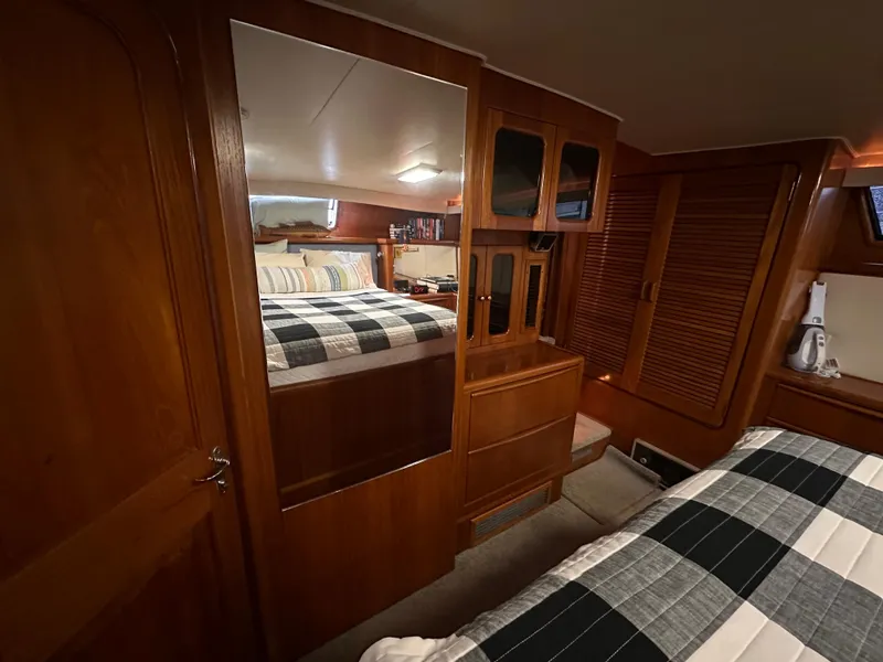 Slide: The Image of 1989 Viking 44 Motor Yacht cabin with wood paneling and plaid bedding. - 26