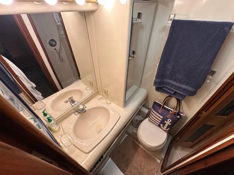Slide: The Image of Bathroom interior of 1989 Viking 44 Motor Yacht with sink, mirror, and nautical decor. - 27