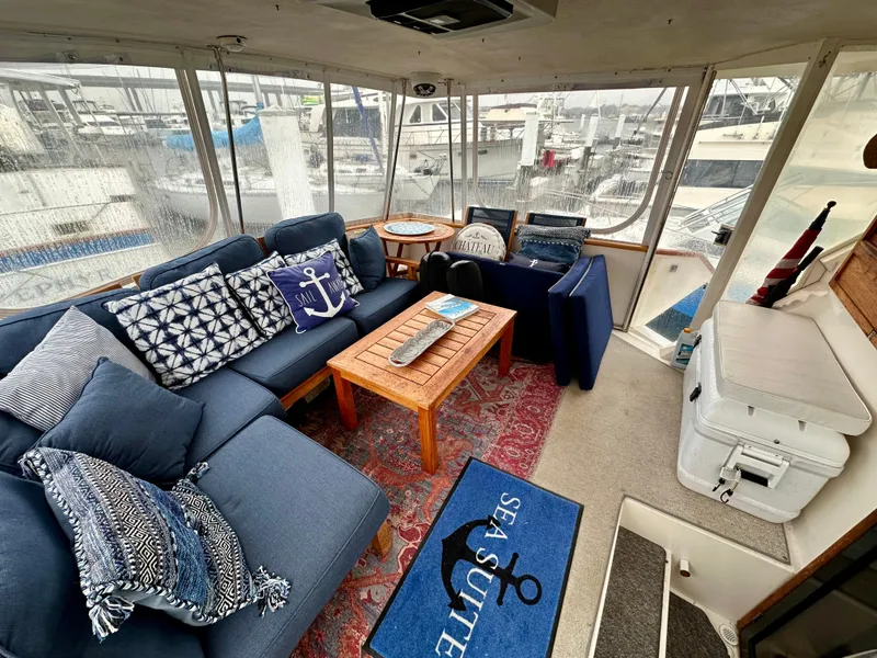 Slide: The Image of 1989 Viking 44 Motor Yacht interior with blue seating, nautical decor, and marina view. - 6
