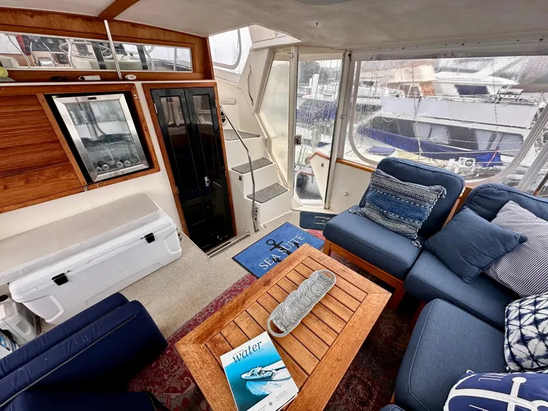 Slide: The Image of 1989 Viking 44 Motor Yacht interior with cozy seating, wooden table, and nautical decor. - 8