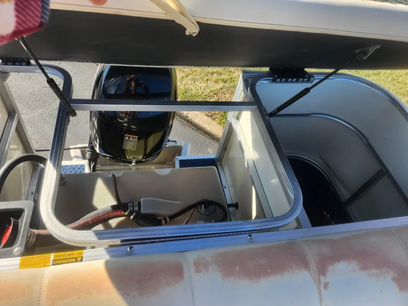 Slide: The Image of 2005 Odyssey 522C boat engine compartment with open hatch, showing motor and storage area. - 15