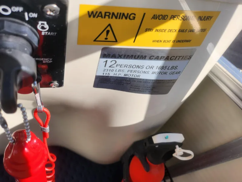 Slide: The Image of Warning label on 2005 Odyssey 522C boat showing capacity and safety instructions. - 20