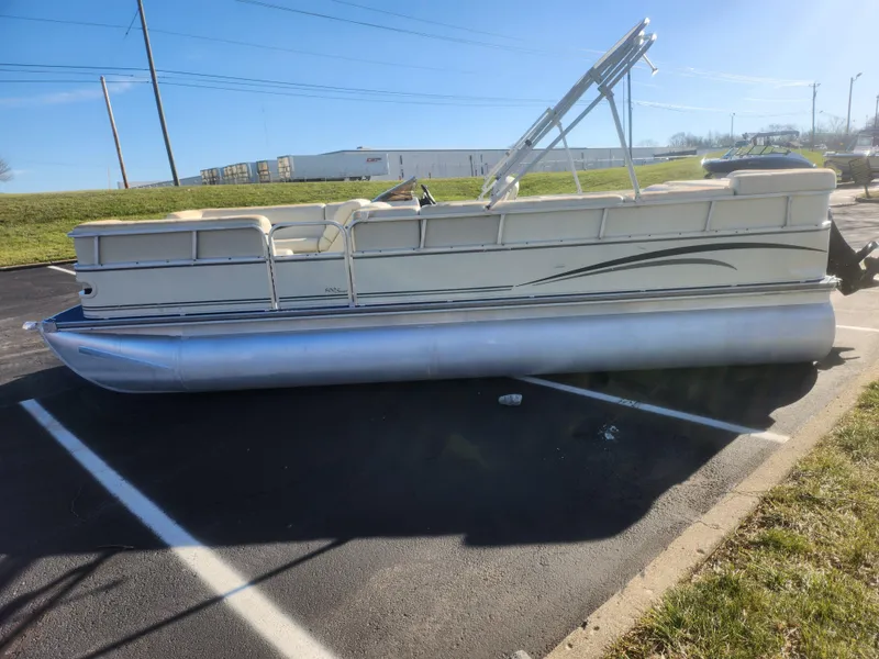 Slide: The Image of 2005 Odyssey 522C pontoon boat parked in a lot under clear blue sky. - 4