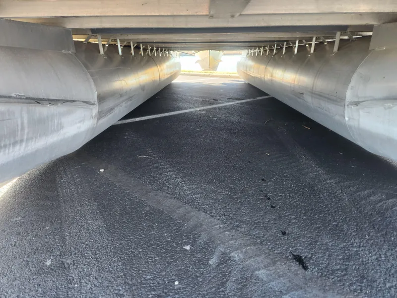 Slide: The Image of Underneath view of a 2005 Odyssey 522C pontoon boat, showcasing dual aluminum pontoons. - 7