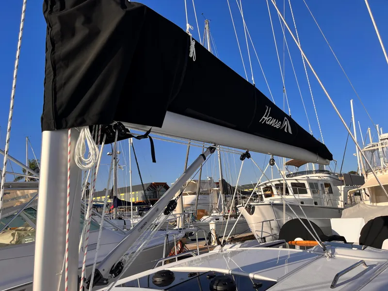 Slide: The Image of 2026 Hanse 348 sailboat with black sail cover docked in marina. - 12