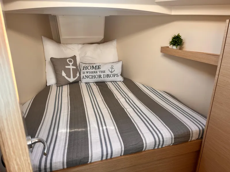 Slide: The Image of Cozy cabin interior of 2026 Hanse 348 yacht with nautical-themed bedding and decor. - 21