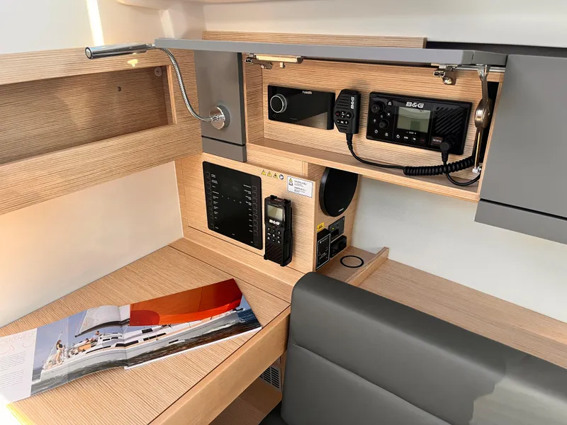 Slide: The Image of Modern navigation station in 2026 Hanse 348 yacht with communication equipment and brochure. - 22