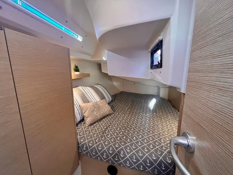 Slide: The Image of Cozy cabin interior of 2026 Hanse 348 sailboat with nautical-themed bedding. - 27