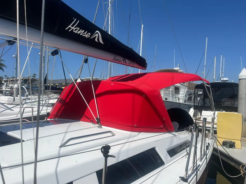 Slide: The Image of 2026 Hanse 348 sailboat with red canopy docked at marina. - 33