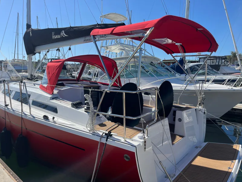 Slide: The Image of 2026 Hanse 348 sailboat with red canopy docked at marina. - 35