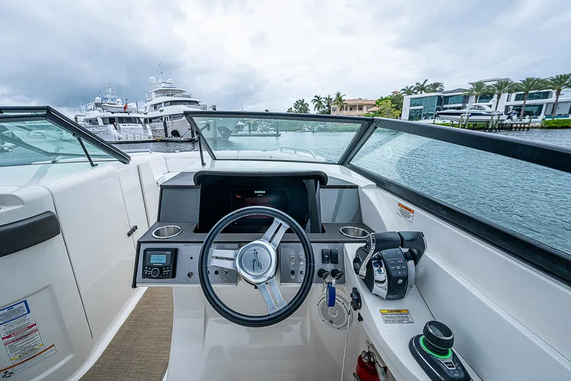 Slide: The Image of 2018 Sea Ray SDX 290 Outboard helm with modern controls and waterfront view. - 10