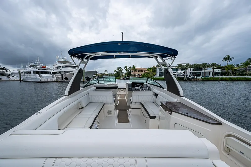 Slide: The Image of 2018 Sea Ray SDX 290 Outboard boat with spacious seating and canopy on a cloudy day. - 18