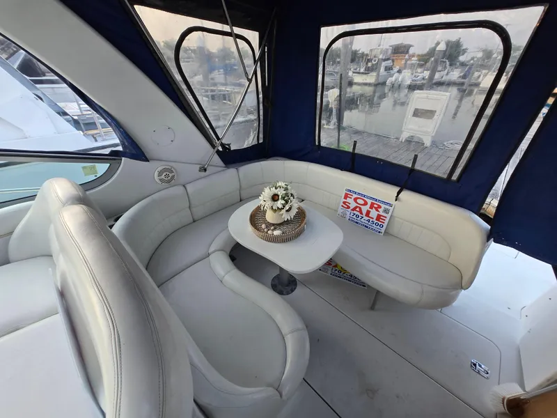 Slide: The Image of 2003 Four Winns 328 Vista boat interior with seating, table, and "For Sale" sign. - 10