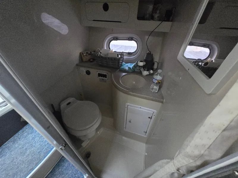 Slide: The Image of 2003 Four Winns 328 Vista boat bathroom with toilet, sink, and window. - 12