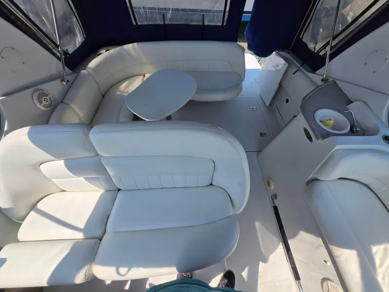 Slide: The Image of 2003 Four Winns 328 Vista boat interior with white seating and compact table. - 14