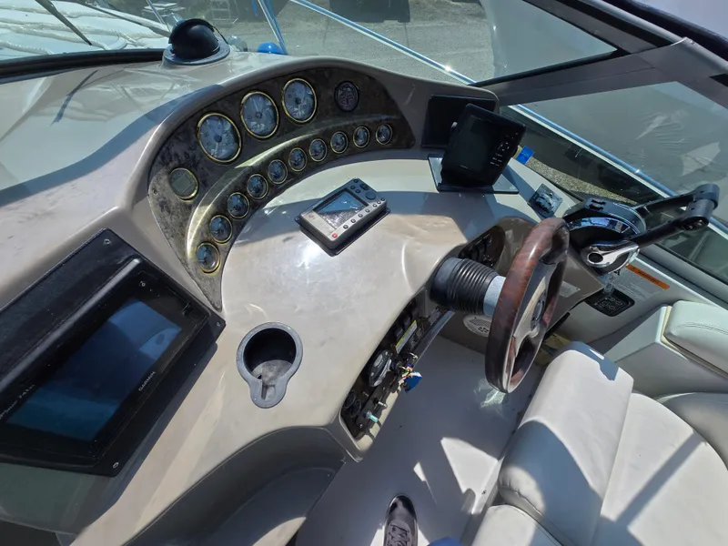 Slide: The Image of 2003 Four Winns 328 Vista boat dashboard with gauges, steering wheel, and navigation equipment. - 16