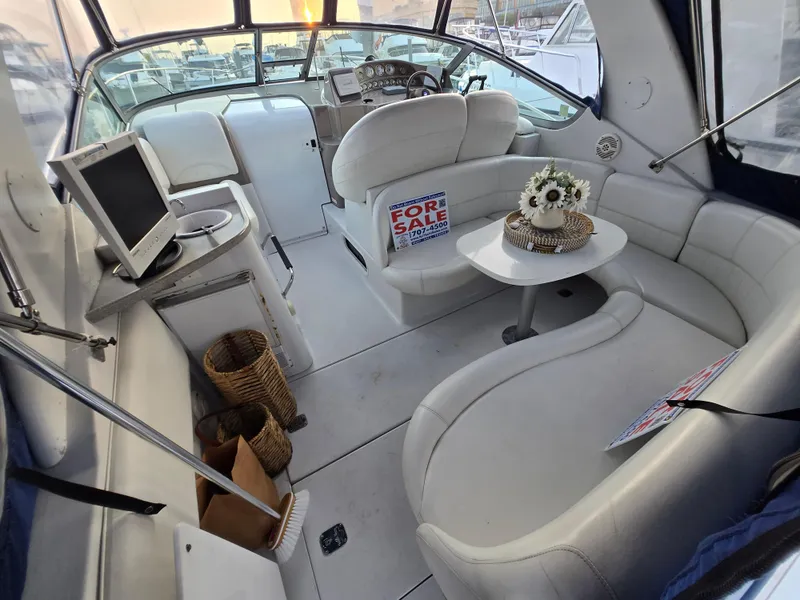 Slide: The Image of 2003 Four Winns 328 Vista boat interior with seating, table, and "For Sale" sign. - 24