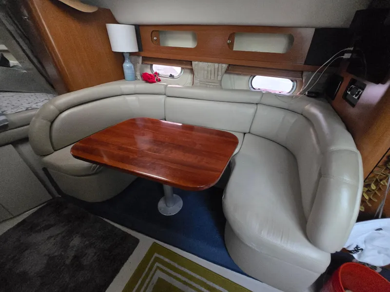Slide: The Image of 2003 Four Winns 328 Vista interior with beige seating and wooden table. - 27